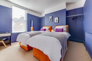 利物浦Air Host and Stay - Rockfield Lodge, sleep 12 free parking next to LFC的卧室设有两张床铺和蓝色的墙壁
