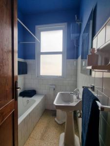 卡瓦尼亚斯El Chalet Amarillo的浴室设有蓝色的墙壁、水槽和浴缸。
