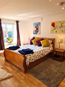 BroomeTopsy-Turvy, Gardeners Cottage, Clungunford, Ludlow, Shropshire SY70PN的一间卧室配有一张带黄色枕头的大型木制床。