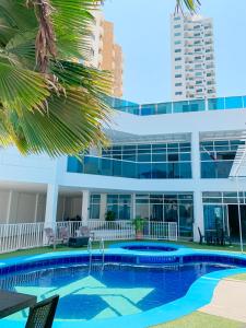 卡塔赫纳Hotel Abi Inn By GEH Suites的大楼前的游泳池