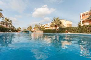 德尼亚Guayaba的一座种植了棕榈树和建筑的大型蓝色游泳池