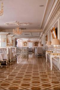 DubovtsyHotel Grand Aristocrate的大型客房配有桌椅和吊灯。