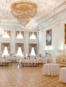 DubovtsyHotel Grand Aristocrate的宴会厅配有白色的桌椅和吊灯