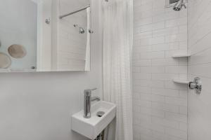 楠塔基特Nantucket Periwinkle的白色的浴室设有水槽和淋浴。