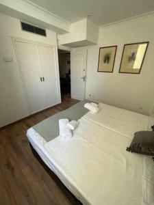 马德里Apartamento IV AlcaláRetiro Ideal Parejas的白色客房 - 带2张床和2条毛巾