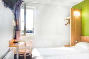 蒙吕松Hotel Inn Design Montluçon的客房设有两张床、一张桌子和一个窗户。