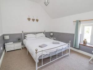 雷克瑟姆Carreg Cottage的卧室配有白色的床和窗户。