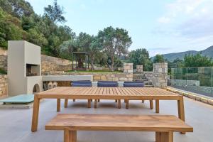 圣特里亚斯Moly - Luxury Villa with Heated Private Pool的露台上的木桌和长凳,配有烧烤架