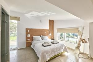 圣特里亚斯Moly - Luxury Villa with Heated Private Pool的白色的卧室设有一张大床和一个窗户