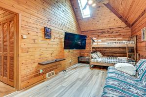 MetamoraMagical Metamora Cottage with Fire Pit, Pond, Deck!的小木屋配有电视和两张双层床。