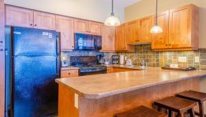 太阳峰Settlers Crossing #61 by Bear Country的厨房配有蓝色冰箱和木制橱柜。