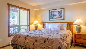 太阳峰Fireside Lodge #413 By Bear Country的一间卧室配有一张带两盏灯的床和一扇窗户。