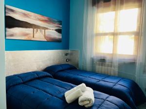拉蒂纳[Chi Ama il Mare] Appartamento的蓝色客房 - 带两张床和一条毛巾