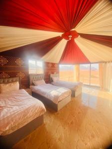 瓦迪拉姆Desert guide camp的一间卧室设有两张床和大窗户