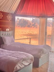 瓦迪拉姆Desert guide camp的一间设有两张床的卧室,享有沙漠美景