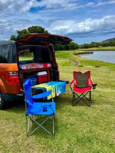 基黑Campervan/Maui hosted by Go Camp Maui的两把椅子坐在汽车前面,一张桌子