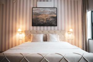 博尔赫隆La Forteresse的一间卧室配有一张带两盏灯的大型白色床。