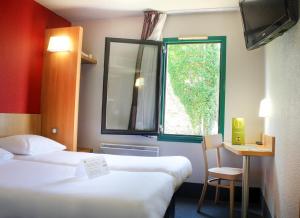 维耶尔宗Hotel Inn design Vierzon - ex B&B的酒店客房设有两张床和窗户。