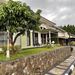 苏加武眉Villa Siku Naim, Sukabumi的前面有石墙的房子