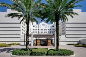 普兰塔寻Sheraton Suites Fort Lauderdale Plantation的两棵棕榈树,在一座建筑前