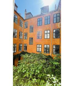 哥本哈根ApartmentInCopenhagen Apartment 1541的一座有植物的旧砖房