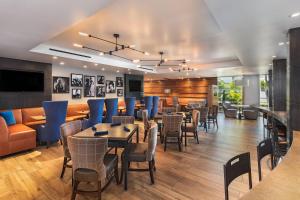 洛杉矶登洛杉矶西部福朋喜来登酒店的一间设有蓝色桌椅的餐厅和一间酒吧