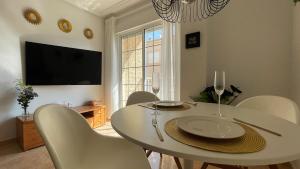 圣佩德罗-德尔皮纳塔尔Low Price Modern Apartment sleeps 4 Fully Aircon的一间配备有白色桌椅的用餐室