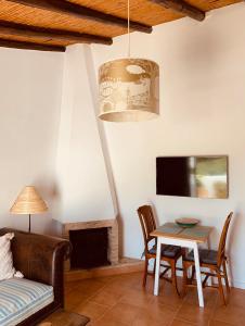 圣布拉什迪阿尔波特尔Casa na Colina : The Cottage and The Long House的带沙发、桌子和电视的客厅