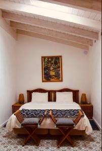 圣布拉什迪阿尔波特尔Casa na Colina : The Cottage and The Long House的一间卧室配有一张大床和两把椅子