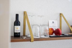 埃因霍温Hotel Auberge Nassau的一瓶葡萄酒和玻璃杯放在带苹果的架子上