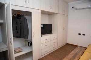 LunluntaFinca Mosso Lunlunta的卧室配有白色橱柜、电视和衣柜。