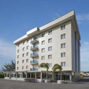 波梅齐亚西蒙酒店 的一座白色的大建筑,前面有棕榈树