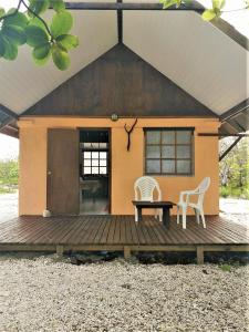 法卡拉瓦FAKARAVA - Teariki Lodge 2的一座房子,配有两把椅子和一张桌子