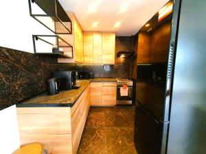 格利维采HappyStay Gold的厨房配有木制橱柜和黑色冰箱。