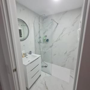 比纳罗斯Apartament Lux的带淋浴和盥洗盆的白色浴室