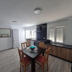 比纳罗斯Apartament Lux的厨房配有桌椅和冰箱。