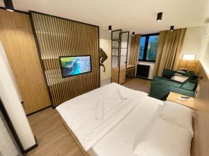 Andrijevica科莫维酒店的卧室配有白色的床和沙发