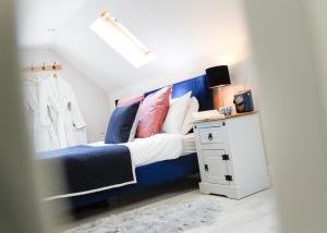 奇平卡姆登Castle Hideaway in the Cotswolds的一间卧室配有蓝色的床和色彩缤纷的枕头