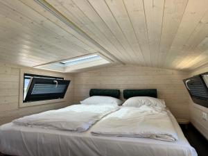羊角村Tiny House Lovely Sunshine的一张位于小客房内的大床,设有天花板