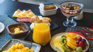 圣地亚哥圣地亚哥维塔库拉诺富特酒店的餐桌上放着食物盘子和一杯橙汁
