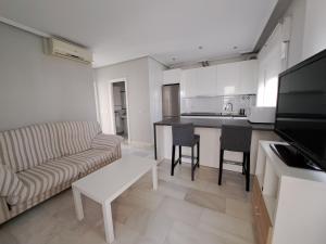 奇克拉纳－德拉弗龙特拉Apartamento Pinares del atlantico的厨房以及带沙发和桌子的客厅。