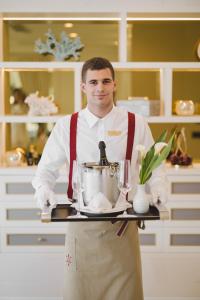 布德瓦Boutique Hotel Vissi d'Arte的把一个装有搅拌器的盘子的厨房里的人