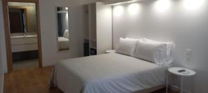 米尔芳提斯城Naturalis的卧室配有白色的床和镜子