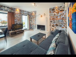 普利瑙港湾DreamStone Residence的带沙发和石墙的客厅