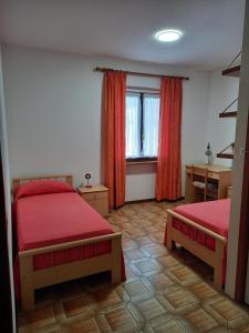 RaveoCasa vacanze Emidia的一间卧室设有两张床和窗户。