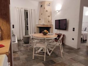 普拉提伊亚洛斯西弗诺斯Melia Sifnos House的一间带桌椅和电视的用餐室