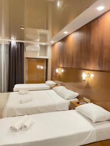 科布列季New House Kobuleti 2的酒店客房,配有3张带白色床单的床
