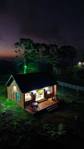乌鲁比西Infinity Valley Cabanas的夜晚在田野上灯火通明的小房子