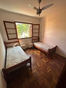 圣若泽杜斯坎普斯Casa Jardim das Colinas的带窗户的客房内的两张床
