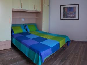 ScaltenigoLa Maison de André的蓝色和绿色的客房内的一张床位